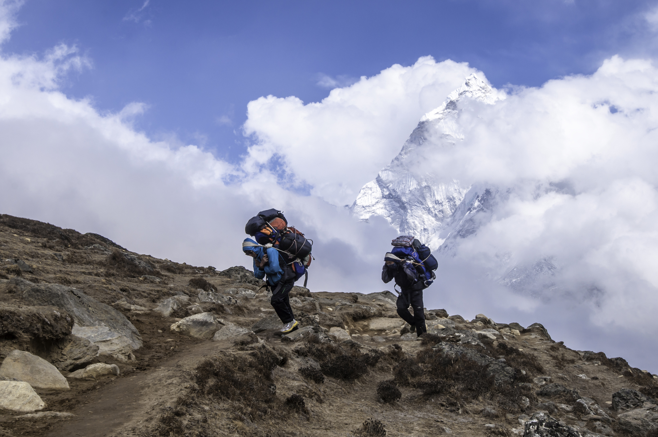 Sherpa carrying expedition kit Himalaya mountain peak Nepal